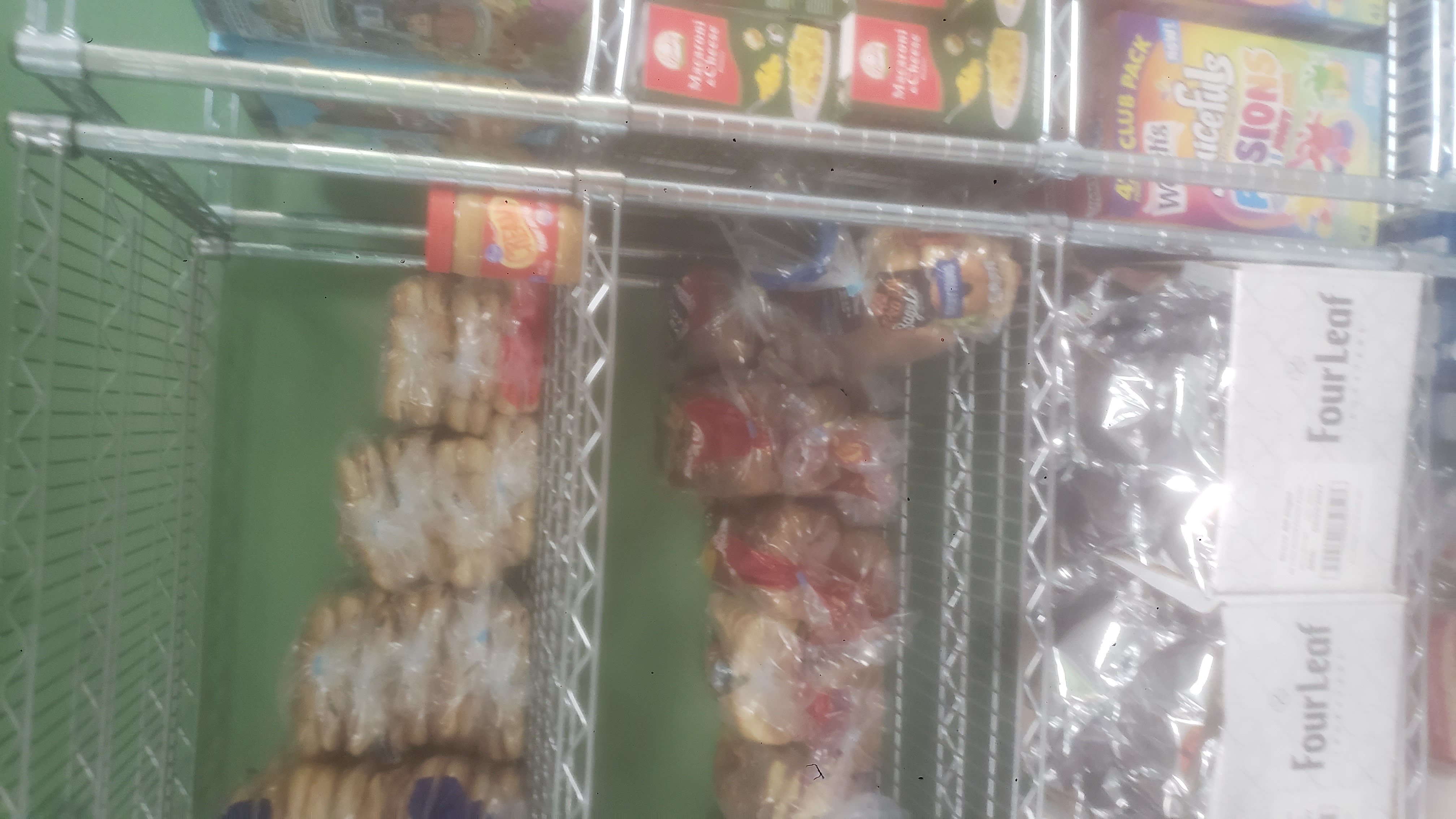 Various breads and coffee packets in a cardboard box on a shelf.